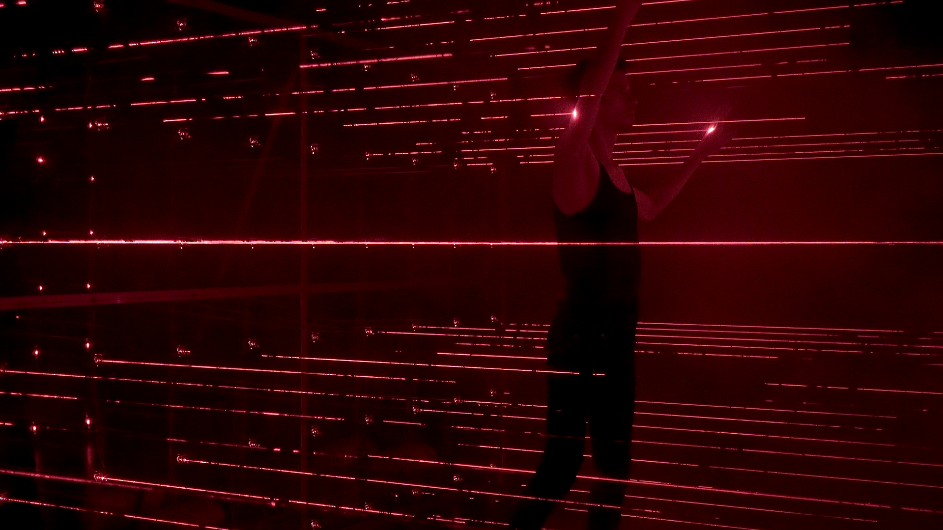 A participant moving between red laser beams.