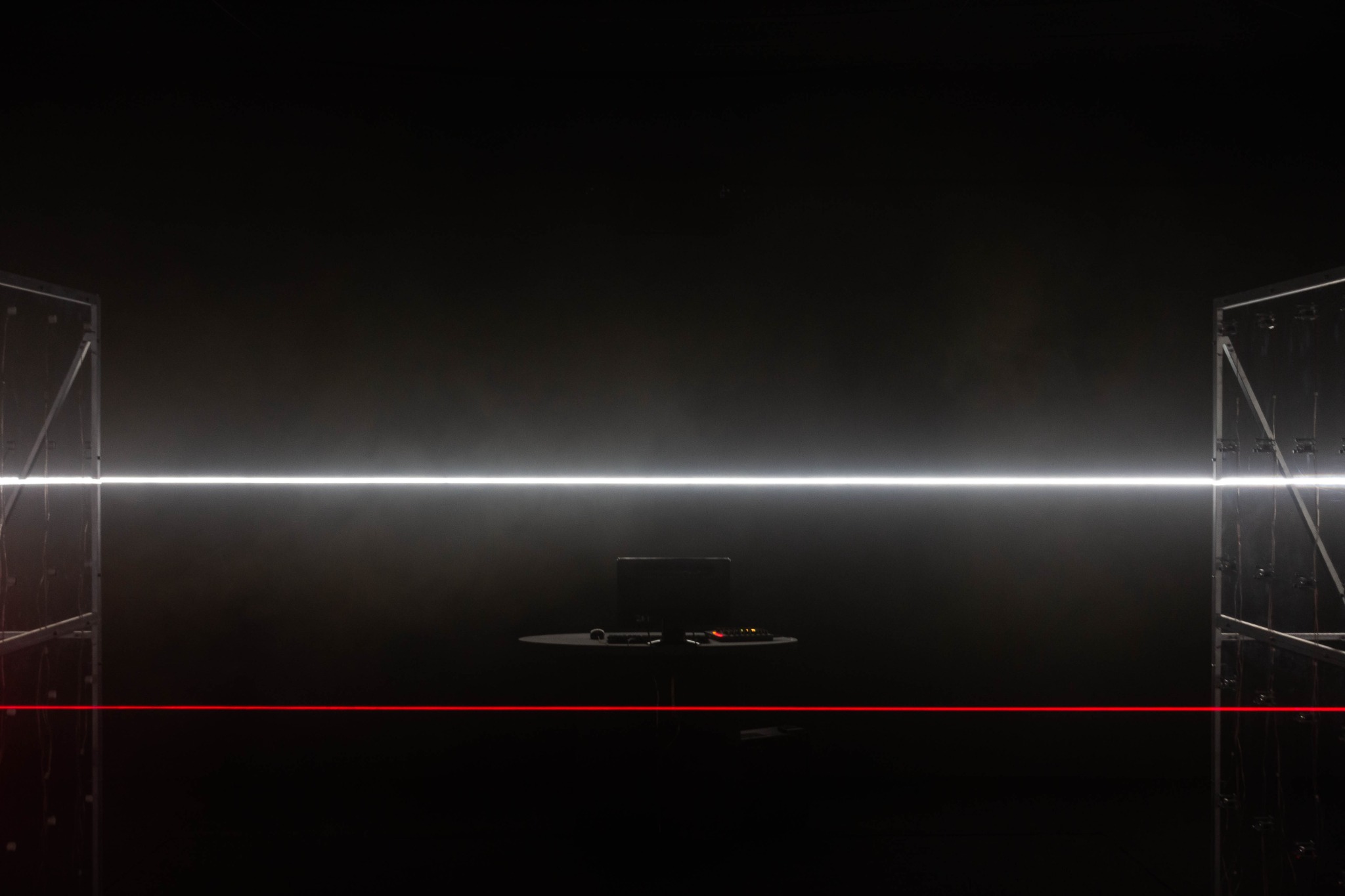 A single red beam and a white horizontal light in the installation space.